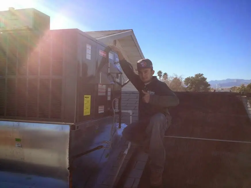 HVAC technician performing AC Tune-Up on a rooftop unit in Corsicana